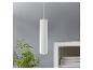 Un luminaire suspendu blanc au design minimaliste, à côté d'une plante et d'une bibliothèque.