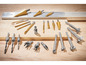Un assortiment de forets, y compris des forets coniques et des forets à bois, sur une table en bois.