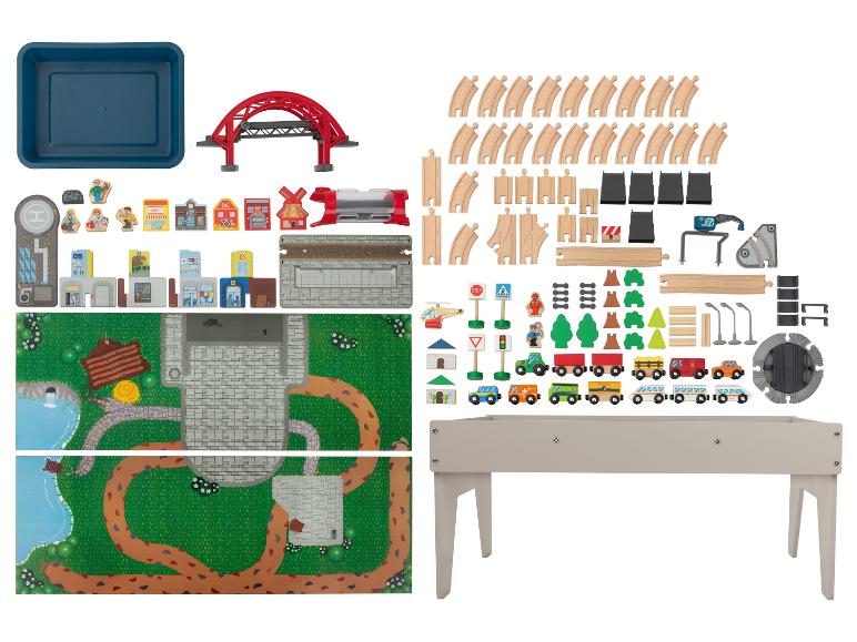 Ensemble de jeu de train en bois avec rails, véhicules, bâtiments et accessoires, plus une table de jeu.