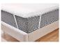 Protège-matelas blanc avec élastiques sur un lit beige.
