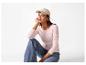 Femme en casquette beige, t-shirt rose à manches longues et jean, accroupie.