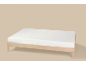 Matelas de bébé à motifs d'étoiles sur un cadre de lit en bois.