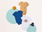 Vêtements pour bébé avec un imprimé de poulpe et de crabe, body bleu et jouets.