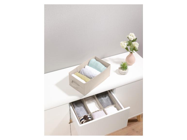 Boîtes de rangement pour vêtements dans une commode blanche.
