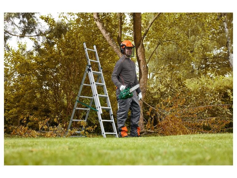 Homme en équipement de sécurité avec tronçonneuse près d'un arbre et d'une échelle.