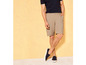 Un homme en short beige et baskets bleues.