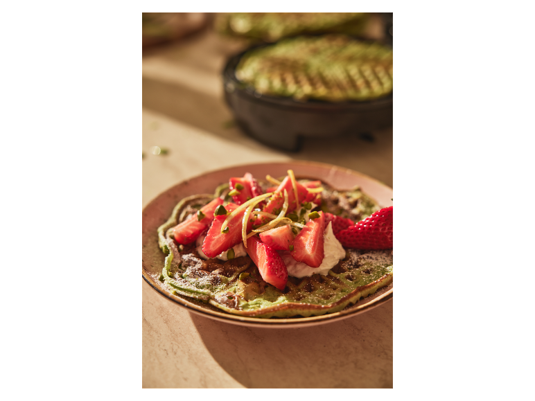 Gaufres vertes avec des fraises et des pistaches.