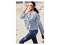 Une femme portant une chemise bleu clair à volants et un jean.