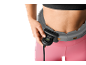 Femme ajustant un hula hoop intelligent gris avec compteur numérique sur sa taille.
