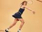 Femme jouant au squash, vêtue d'une jupe et d'un haut assortis.