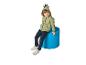Enfant souriant en sweat à capuche dinosaure vert et jean, assis sur un tabouret bleu.