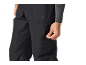 Gros plan d'une personne ajustant la fermeture éclair d'un pantalon de sport noir.