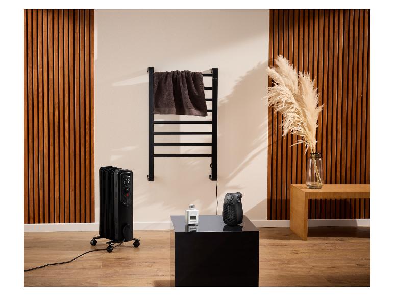 Radiateur à bain d'huile noir et sèche-serviettes dans une pièce moderne.