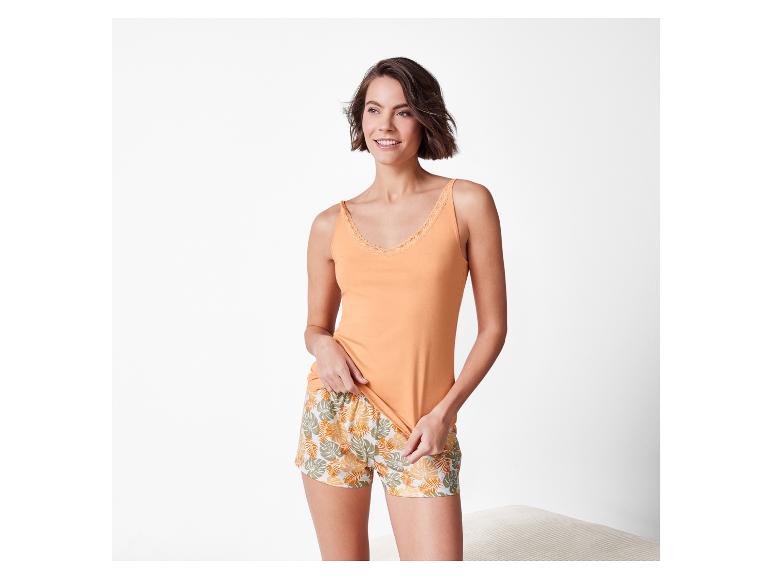 Haut et short de nuit : haut orange et short imprimé feuilles tropicales.