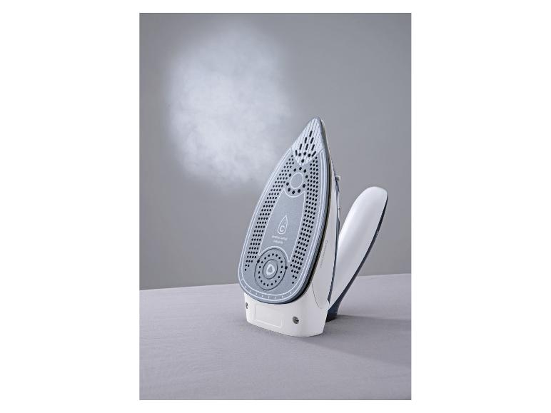 Fer à vapeur avec semelle en céramique, émettant de la vapeur, sur une surface gris clair.