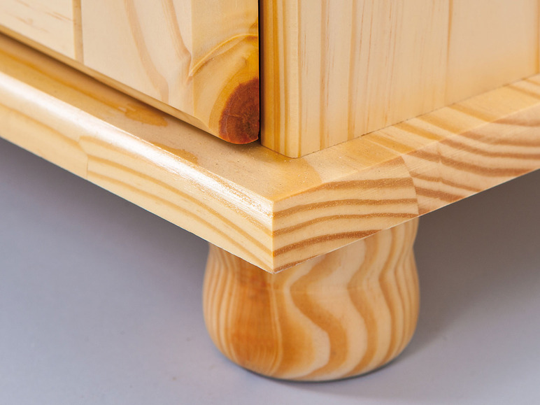 Détail d'une armoire en bois avec des pieds.
