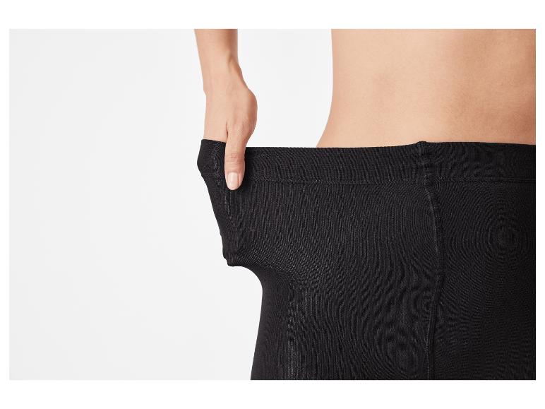 Personne tirant sur la ceinture d'un collant noir pour montrer l'élasticité.