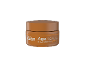 Pot orange de crème de jour avec le texte « AgeBeauty Miel de Manuka Jour ».