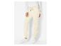 Pantalon de survêtement jaune clair avec des baskets blanches.