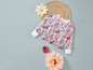Un pull blanc à imprimé floral, un dessous de plat en paille et des fleurs