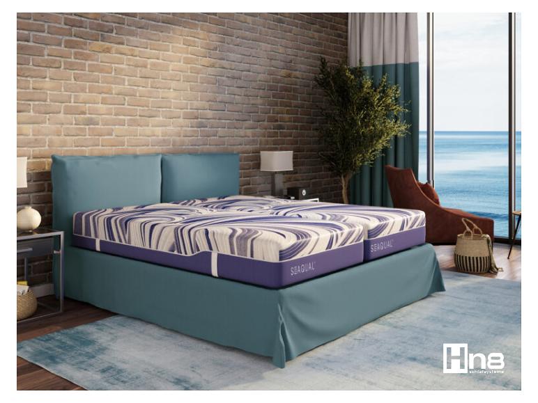 Chambre avec lit Hn8 Sequal, mur en briques et vue sur la mer.