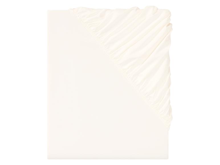 Un drap housse en coton blanc avec élastique.