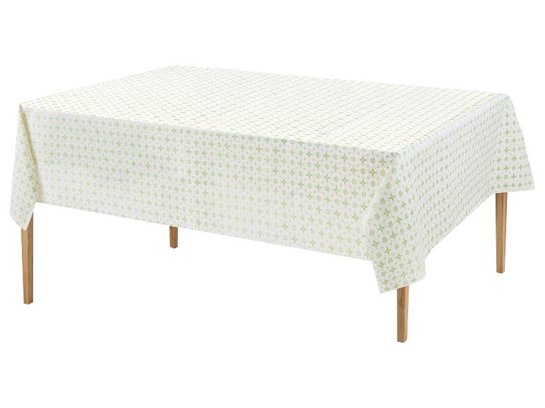 Nappe blanche avec un motif géométrique vert sur une table en bois.