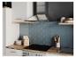 Cuisine moderne avec hotte, plaque de cuisson et carrelage bleu.