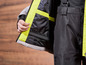 Une veste de ski noire avec des accents jaunes, ouverte pour montrer l'intérieur.