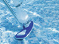 Un aspirateur de piscine bleu avec une perche télescopique dans une piscine.
