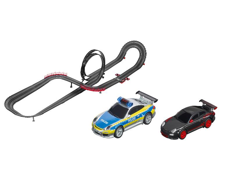 Un circuit de course Carrera avec une Porsche de police bleue et une Porsche noire.