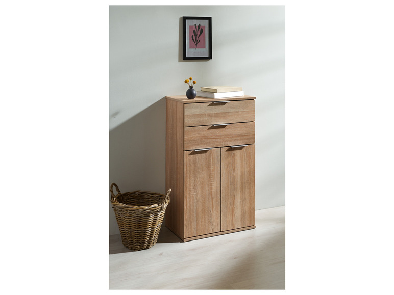 Une armoire en bois avec deux portes et deux tiroirs, à côté d'un panier en osier.