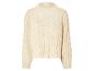 Pull beige en maille torsadée.