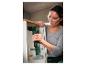 Une femme utilise une perceuse-visseuse sans fil Parkside X-Ion 4.0Ah pour fixer une armoire.