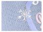 Gros plan d'un tissu bleu clair avec un flocon de neige argenté et du texte rose et blanc partiellement visible.