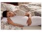 Une femme dort sur un oreiller blanc matelassé.