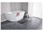 Une baignoire autoportante avec une serviette rose, un tapis de bain gris et une petite table