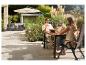 Couple profitant de boissons et de fruits à une table de patio avec parasol et salon de jardin.