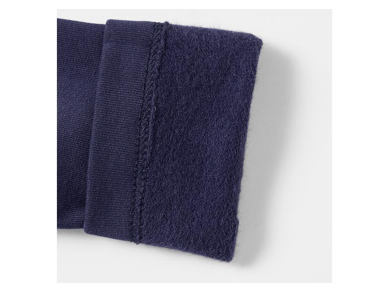 Gros plan de tissu tricoté et polaire bleu foncé, joint par une couture.