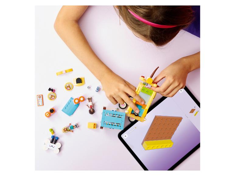 Enfant construisant une voiture jouet avec des blocs colorés, guidé par une tablette.