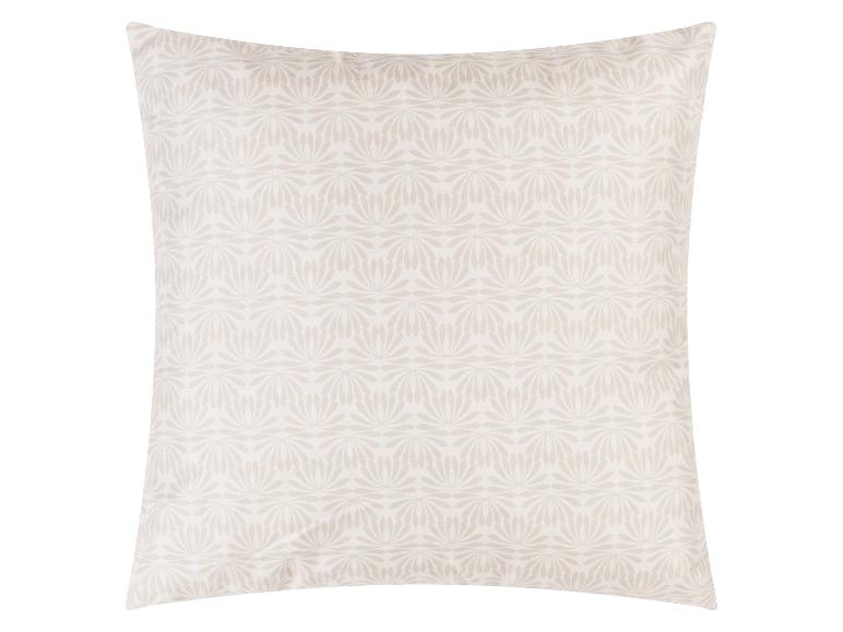 Coussin décoratif beige à motif floral.