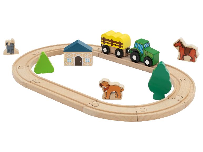 Ensemble de jouets en bois sur le thème de la ferme avec tracteur, wagon, animaux et rails.