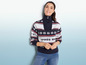 Une femme porte un pull bleu avec des flocons de neige et l'inscription 'Après Ski'.