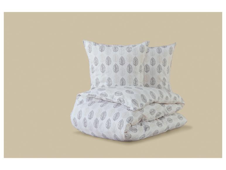 Parure de lit blanche avec motif de feuilles marron et beige.