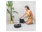 Une femme en robe jaune avec un aspirateur robot Conga et un robot laveur.