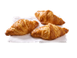 Trois croissants dorés sur une serviette blanche.