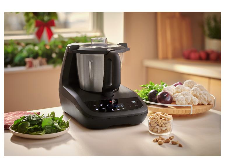 Robot de cuisine SILVERCREST® Monsieur Cuisine compact en coloris anthracite sur le plan de travail avec des ingrédients.