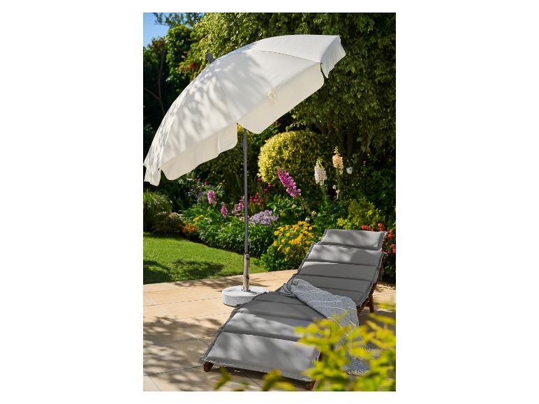Parasol de jardin blanc et chaise longue grise avec un plaid bleu sur une terrasse.