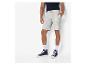 Un homme porte un short de survêtement gris et des baskets bleu foncé.
