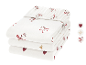 Pile de draps-housses blancs avec cœurs rouges, étoiles dorées et motifs de cannes à sucre.